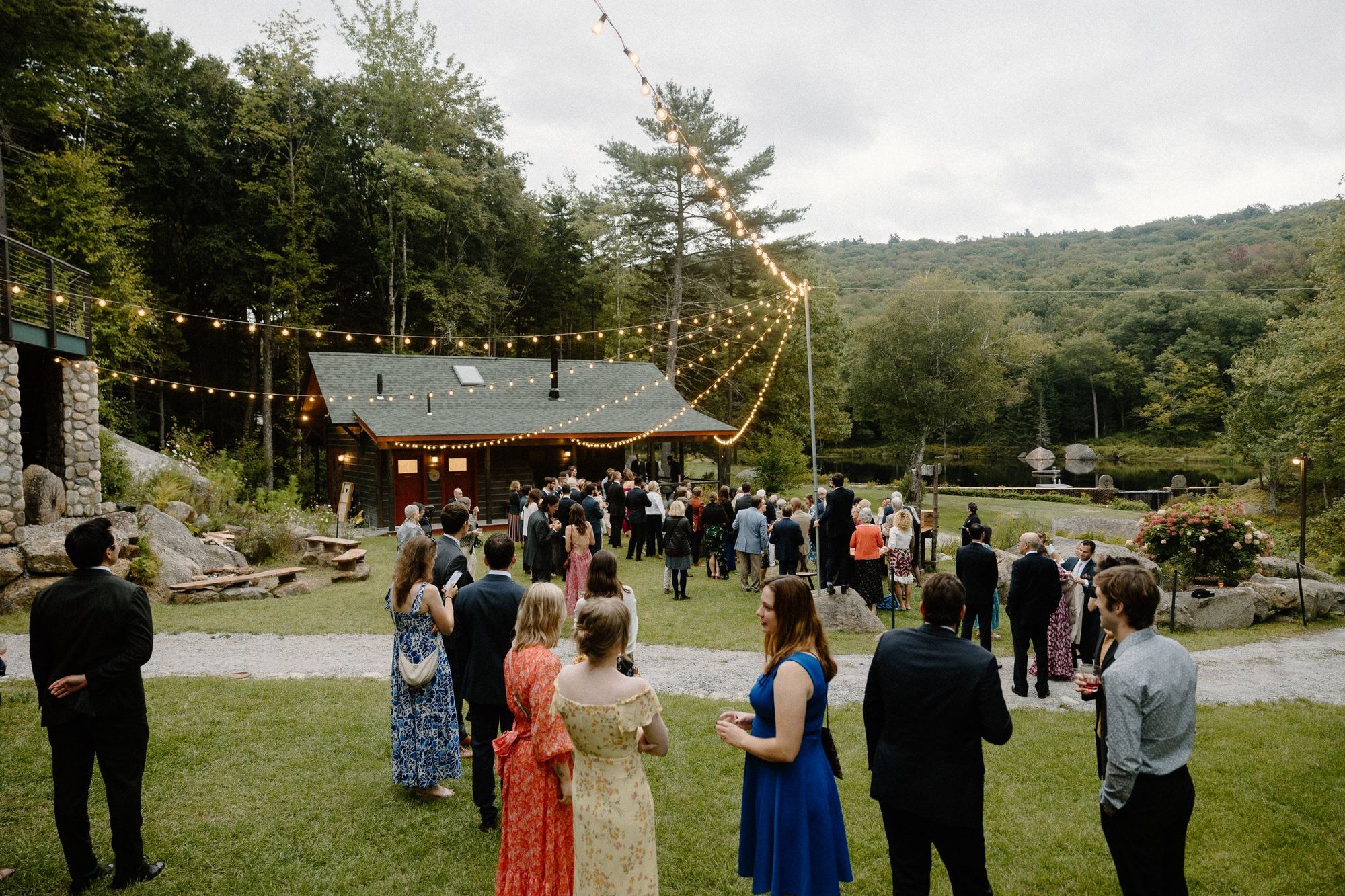 Guests gathered on the lawn below the Barn under string lights